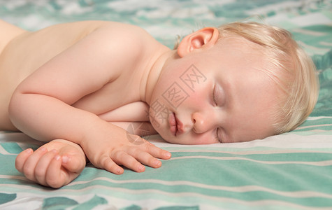 一个可爱的白金发白种人婴儿睡梦躺在室图片