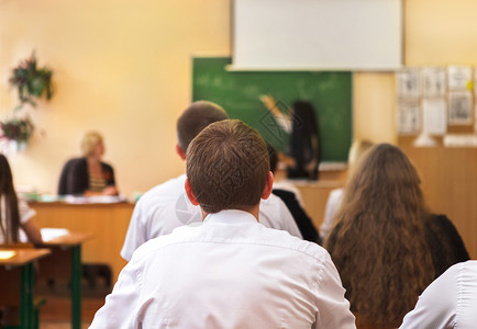 在教室桌旁监听女学生的心目中留心倾听女学生的图片