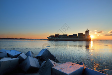 大型集装箱货轮在日落前航行里图片
