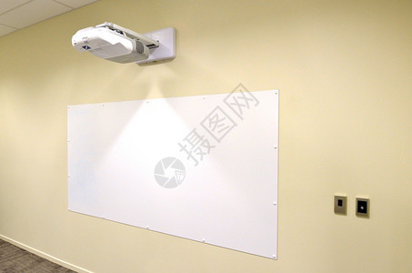 带有视频图像投影仪的投影屏幕挂在室的墙上商业工作场所的概念照图片