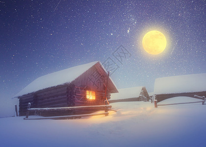 冬季风景有星空和满月山上小木屋的光亮图片