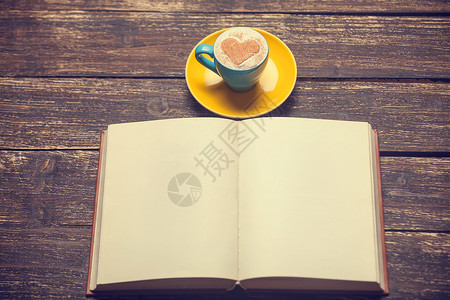 一杯有心形和书的咖啡图片