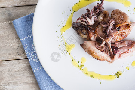 用欧芹和橄榄油装饰的烤小鱿鱼图片