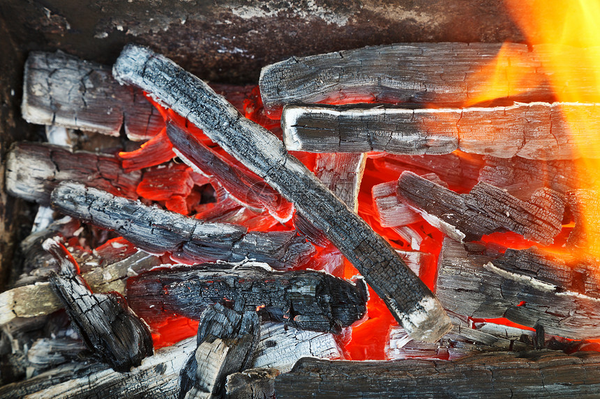 燃烧着木头的热煤上的火焰关闭图片
