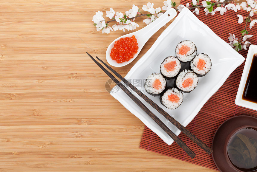 红鱼子酱寿司套樱树枝和竹桌边有复图片