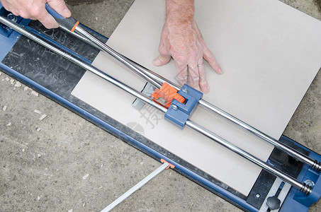 铺设地砖使用瓷砖切割机的瓷砖工图片