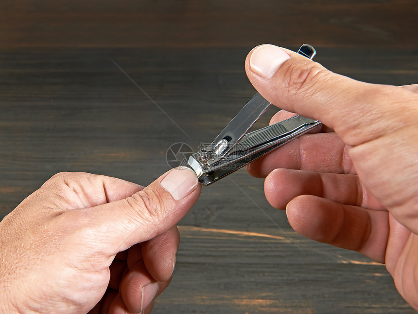 特写镜头显示一个人剪指甲的手图片