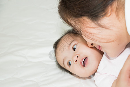 幸福快乐的家庭亚裔母亲和婴儿接吻图片
