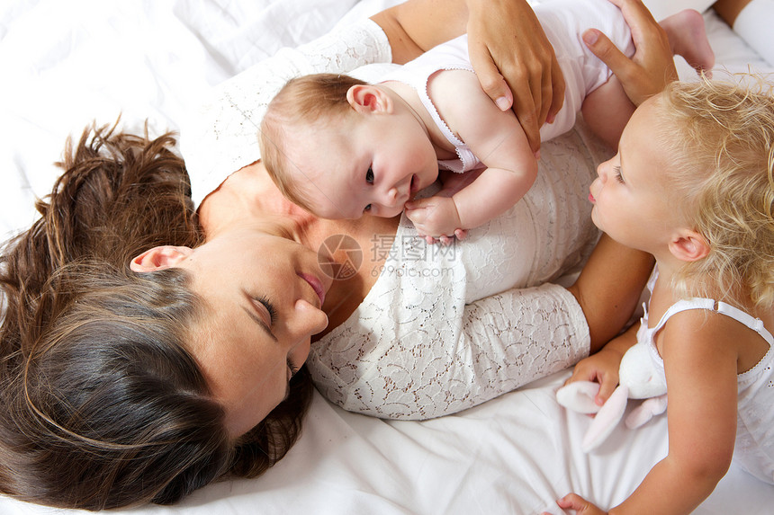 亲近母亲和孩子在床上合图片