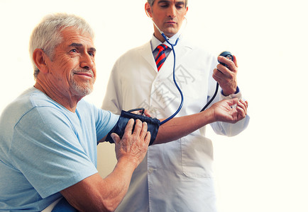 年轻医生测量一个老人的血压孤立于图片