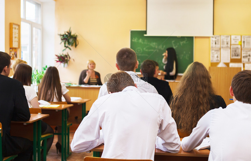 在教室桌旁监听女学生的心目中留心倾听女学生的图片