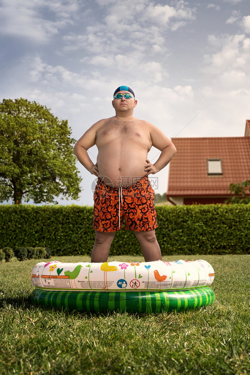 有趣的超重男子即将在后院游泳池游泳图片