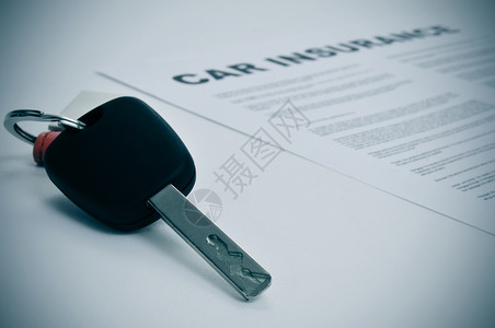 汽车钥匙和汽车保险单的特写图片