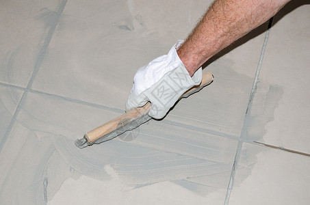 铺设地板砖用橡皮格填满瓷砖图片