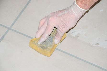 铺地砖贴砖工用海绵抹平瓷砖接缝高清图片