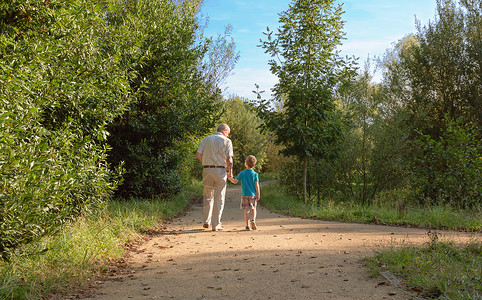 祖父和孙子走在自然道路图片