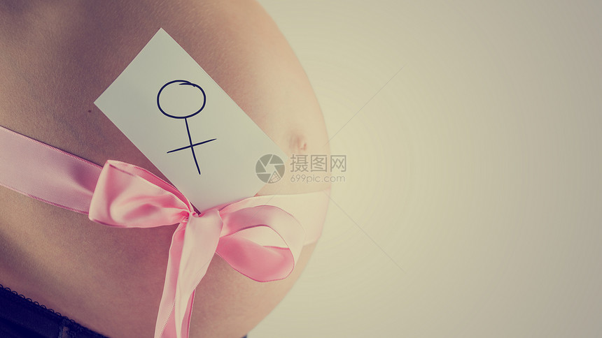 一位年轻孕妇的肿胀裸露腹部的侧面图图片