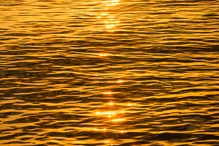 湖上日落的金色反射水面图片