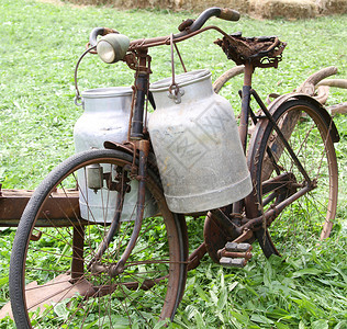 挤奶工的老旧自行车生锈两罐安眠牛奶图片
