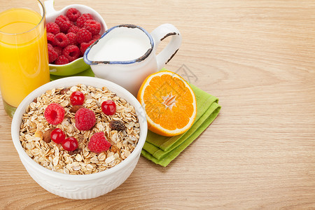 木桌上的健康早餐包括麦片浆果牛奶和橙汁图片