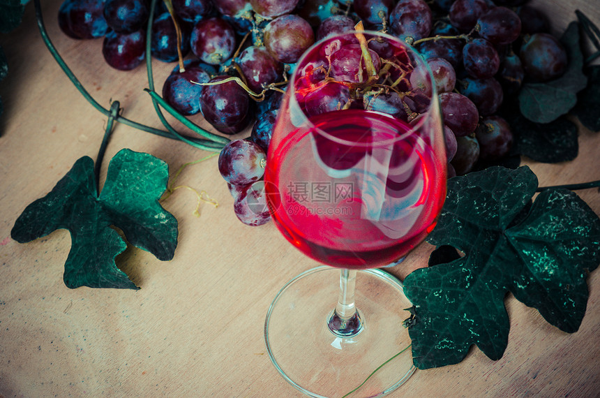木背景上的红酒和红葡萄红酒的静物图片