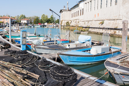 泻湖中的渔网纱架和渔船马拉诺意大利图片