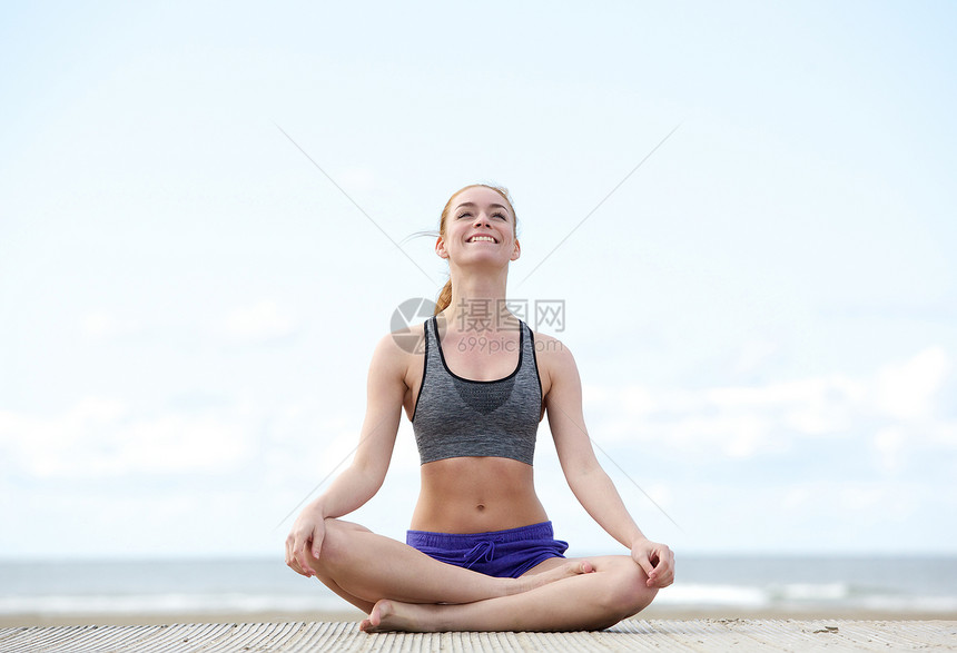 一位坐在瑜伽姿势和户外微笑的年图片