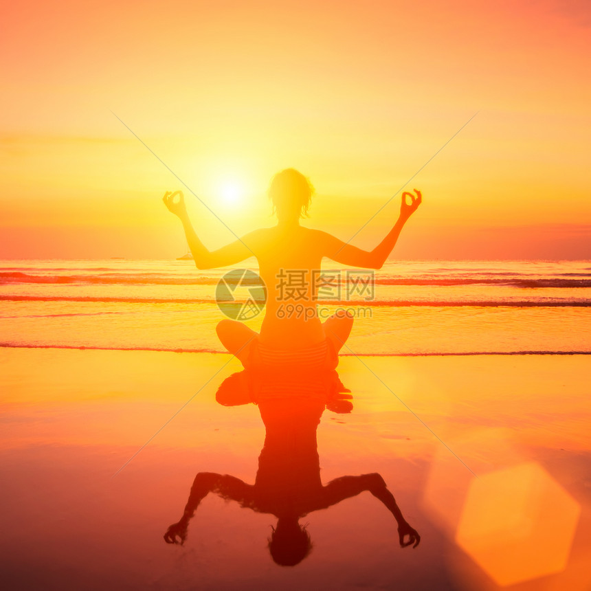 瑜伽女神在海日落和水中图片