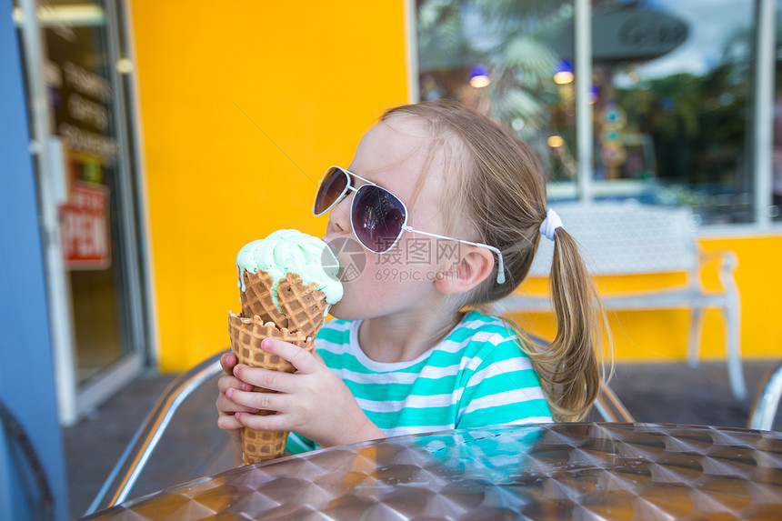小女孩在户外咖啡馆吃冰淇淋图片