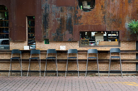 老式自助餐厅的咖啡椅靠在砖墙上图片