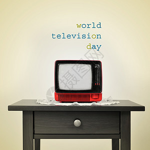 一张桌子上的古老红色电视和一句话上的世界电视日以蜜蜂背景图片