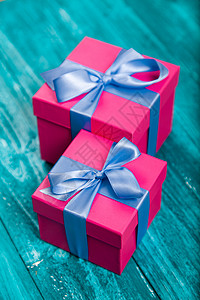 蓝色木头上的粉色礼盒图片