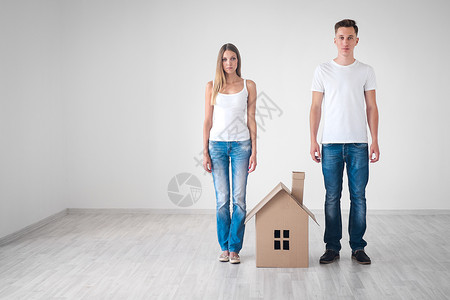 有纸板房子的年轻夫妇背景图片