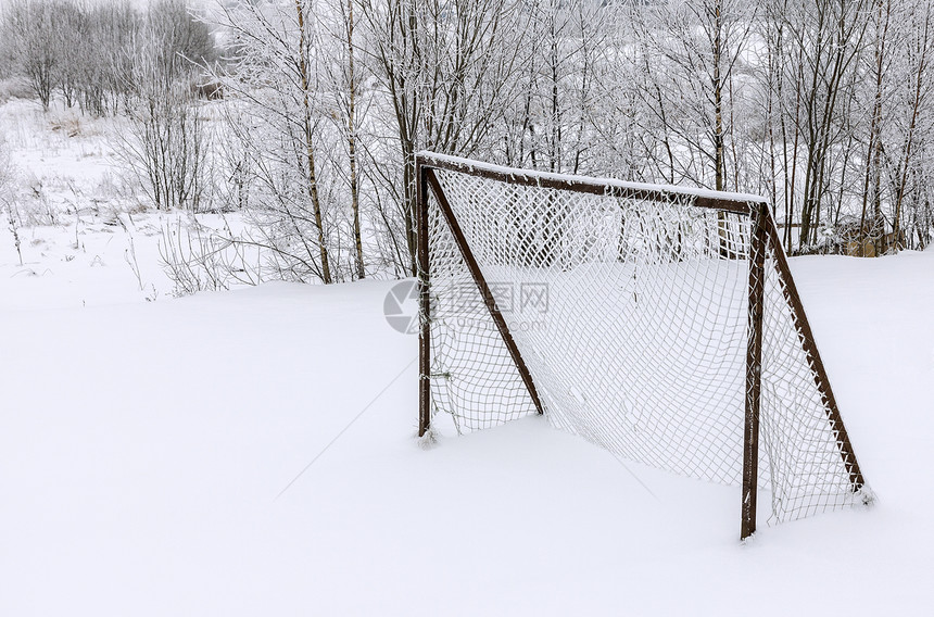 冬季被雪覆盖的旧遗弃的木制足球目图片
