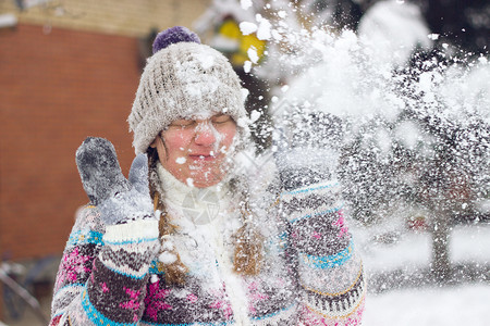 一个皱着眉头的年轻女子在打雪仗时脸上被雪背景图片