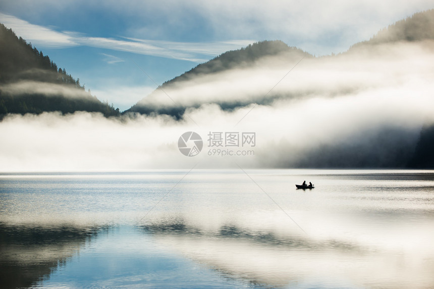 早上在山湖中与一艘孤单的游艇一起在高图片