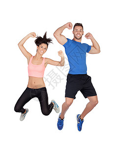 年轻活跃运动服装夫妇与高举手跳跃白种图片