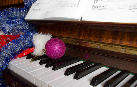 庆祝新年和圣诞节的属都放在钢琴上在有笔记图片