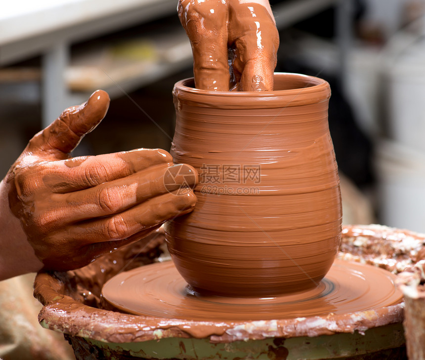 陶工的手创造了一个陶罐图片