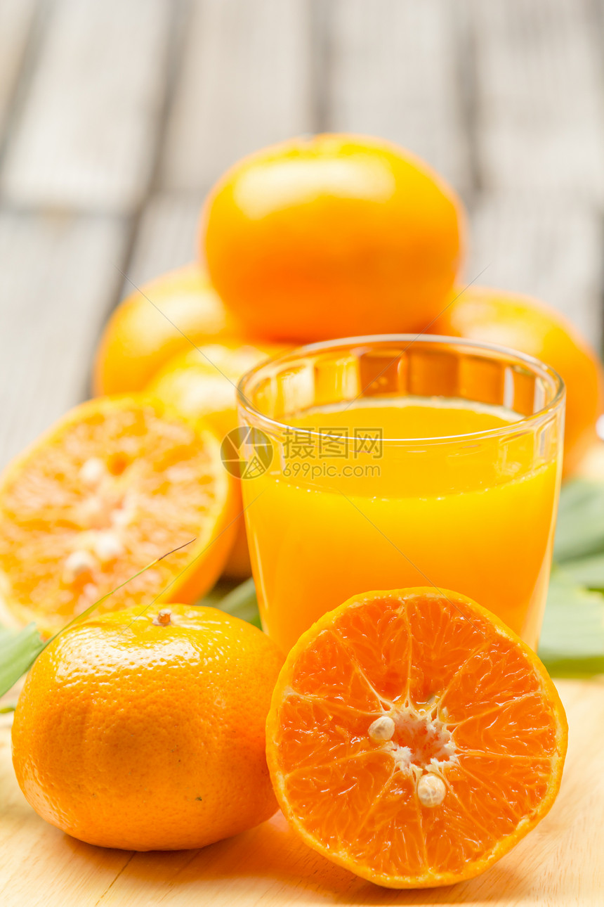 切板上的橙汁和橙子图片