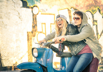一对年轻的恋人在一辆老式摩托车轻便摩托车上玩得开心图片