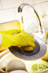 男人戴着黄色手套在厨房洗碗图片