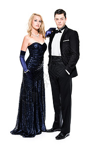 浪漫的新年夜情侣穿着黑色晚饭夹克和深蓝色礼服图片