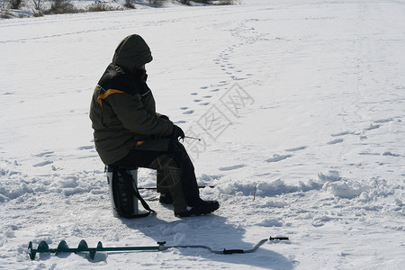 一个人在冬天在河冰上钓鱼图片