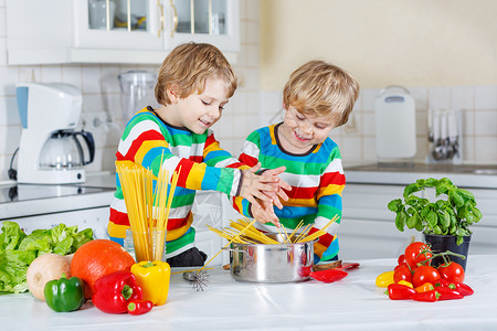 在家里的厨房里用意大利面和新鲜蔬菜做意大利餐图片