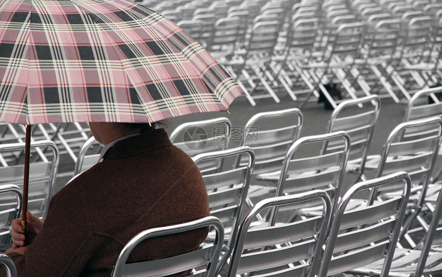 单旁观者在下雨时等待铝制椅子上节目的图片