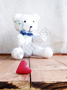 情人节木制表面上的心形和泰迪熊图片