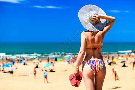 在海滩上戴大遮阳帽的女人图片