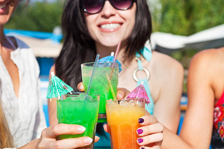 夏日派对上喝饮料的快乐女孩在泳池图片