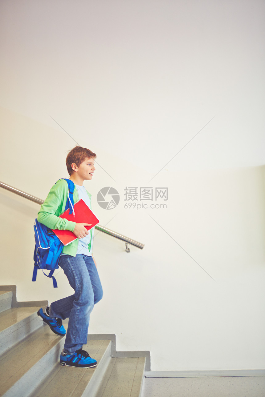 背着书包下楼的青春期前小学生图片